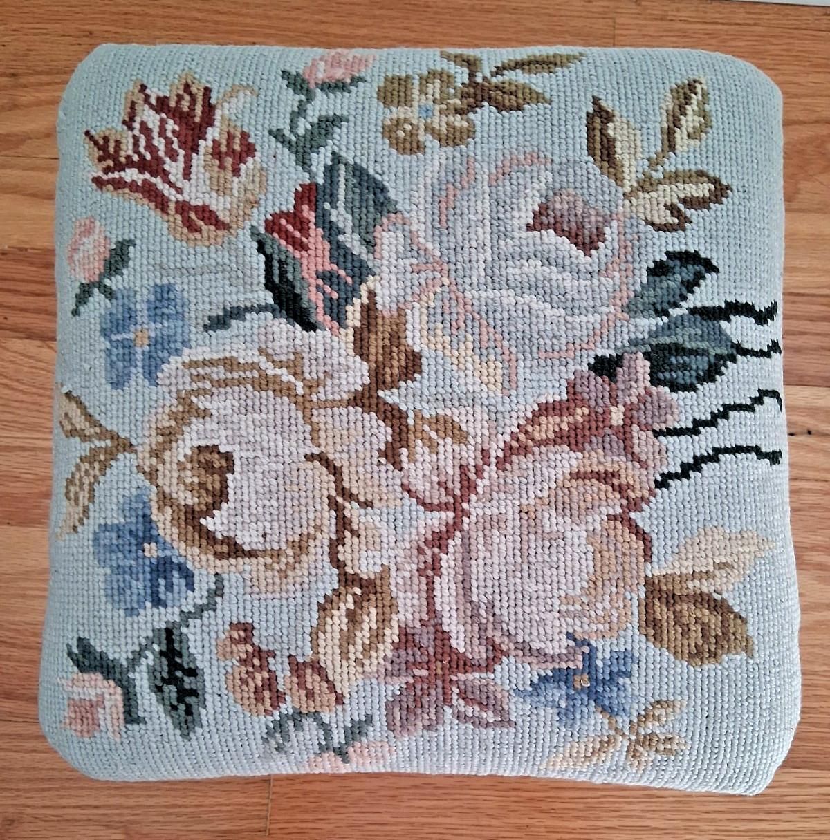 Vintage needlepoint ottoman stool with floral design and cast iron legs