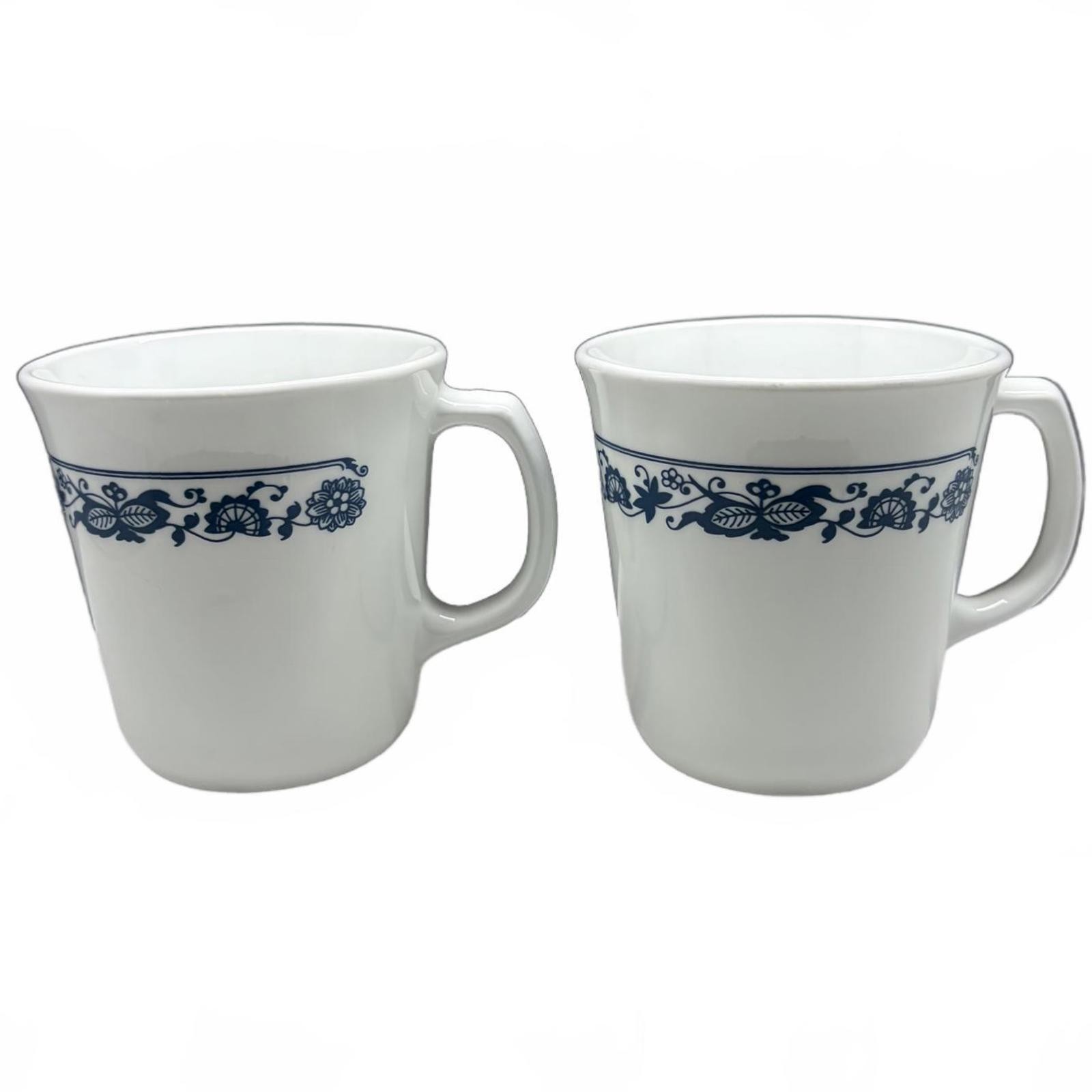 Two white Corning Ware Old Town Blue ceramic mugs with blue floral border.