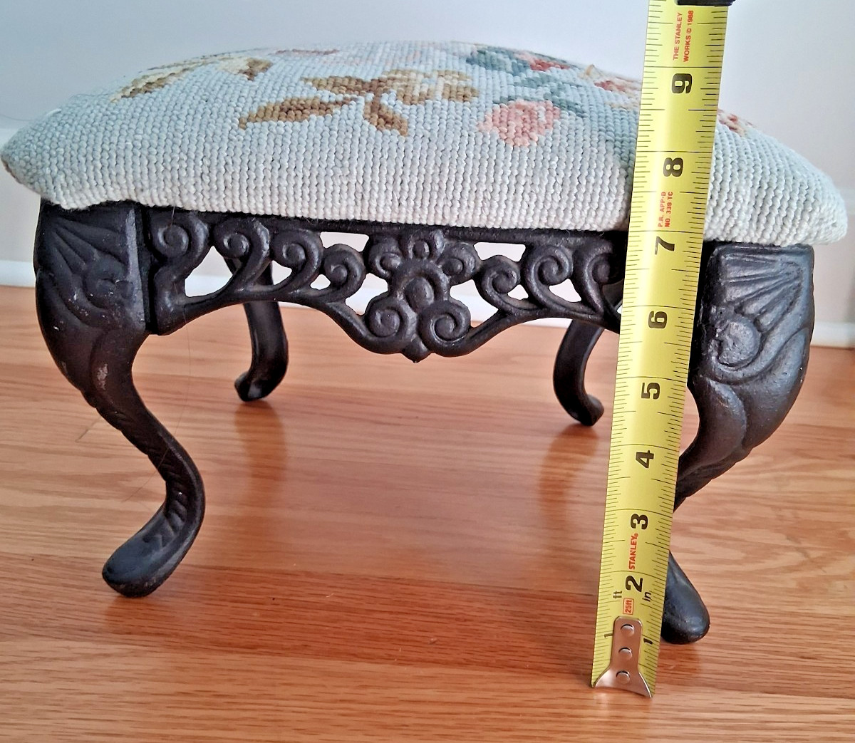 Vintage needlepoint ottoman stool with floral design and cast iron legs
