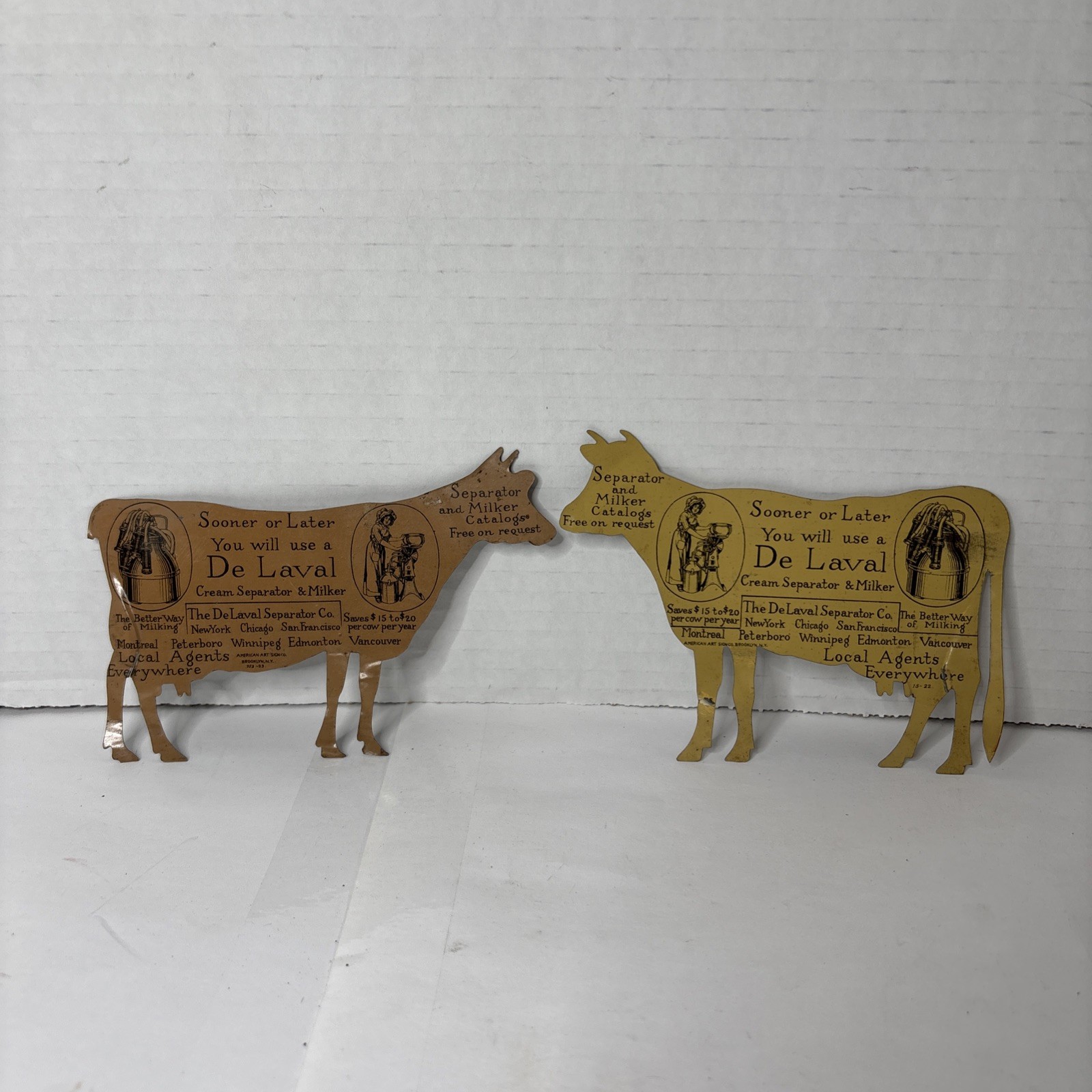 Pair of Antique DeLaval tin die cut cow and calf advertising cream separator ads
