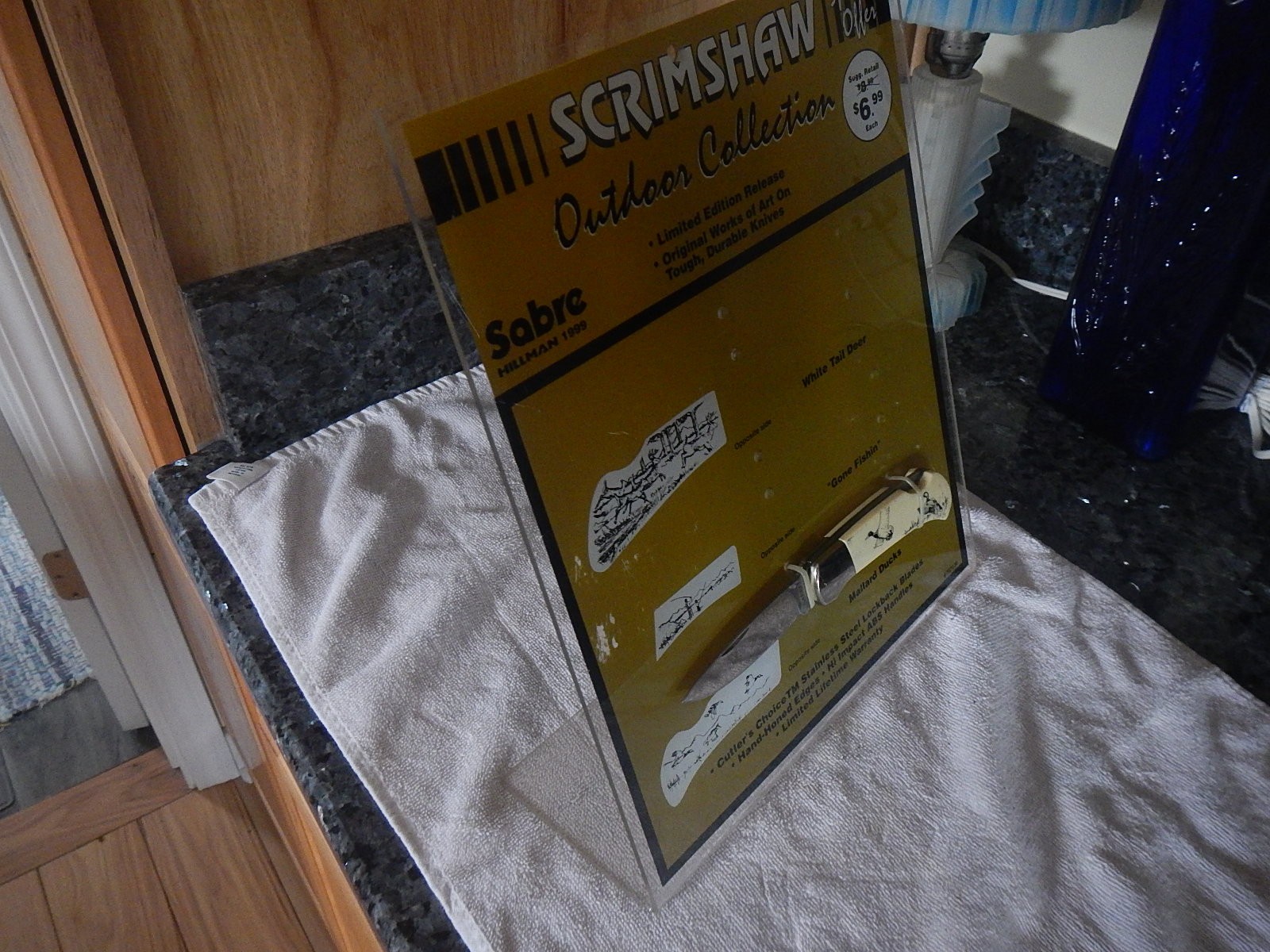 Vintage Sabre scrimshaw knife counter top store display with one NOS knife