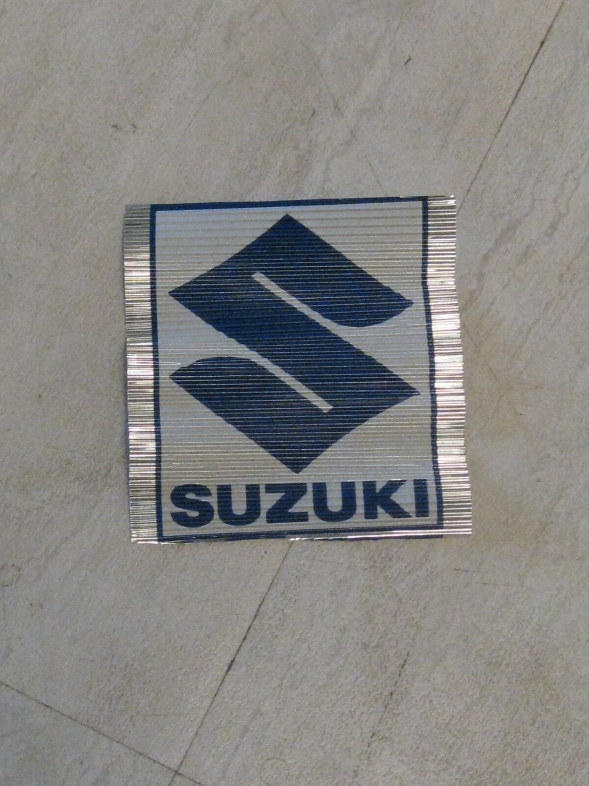 SUZUKI VINTAGE DEALER DISPLAY ALUMINUM CORRUGATED SUZUKI "S" HANG TAG NOS!