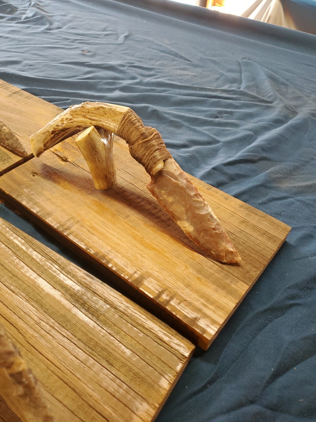 Flint Knapped Stone Arrowhead Blade Knife with Deer Antler Handle on Wood Stand