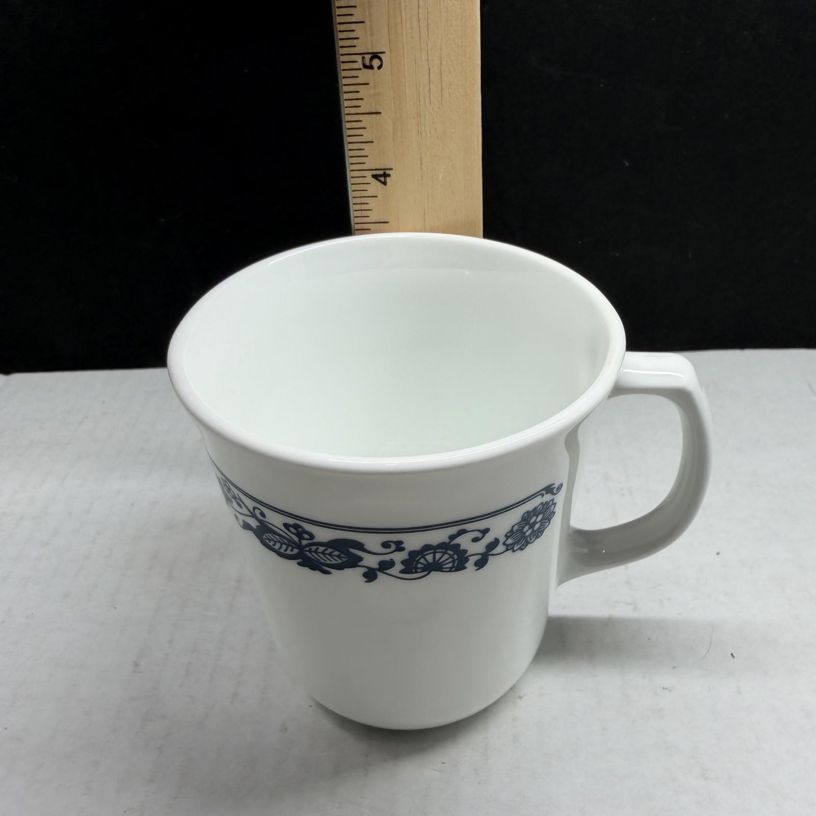 Two white Corning Ware Old Town Blue ceramic mugs with blue floral border.