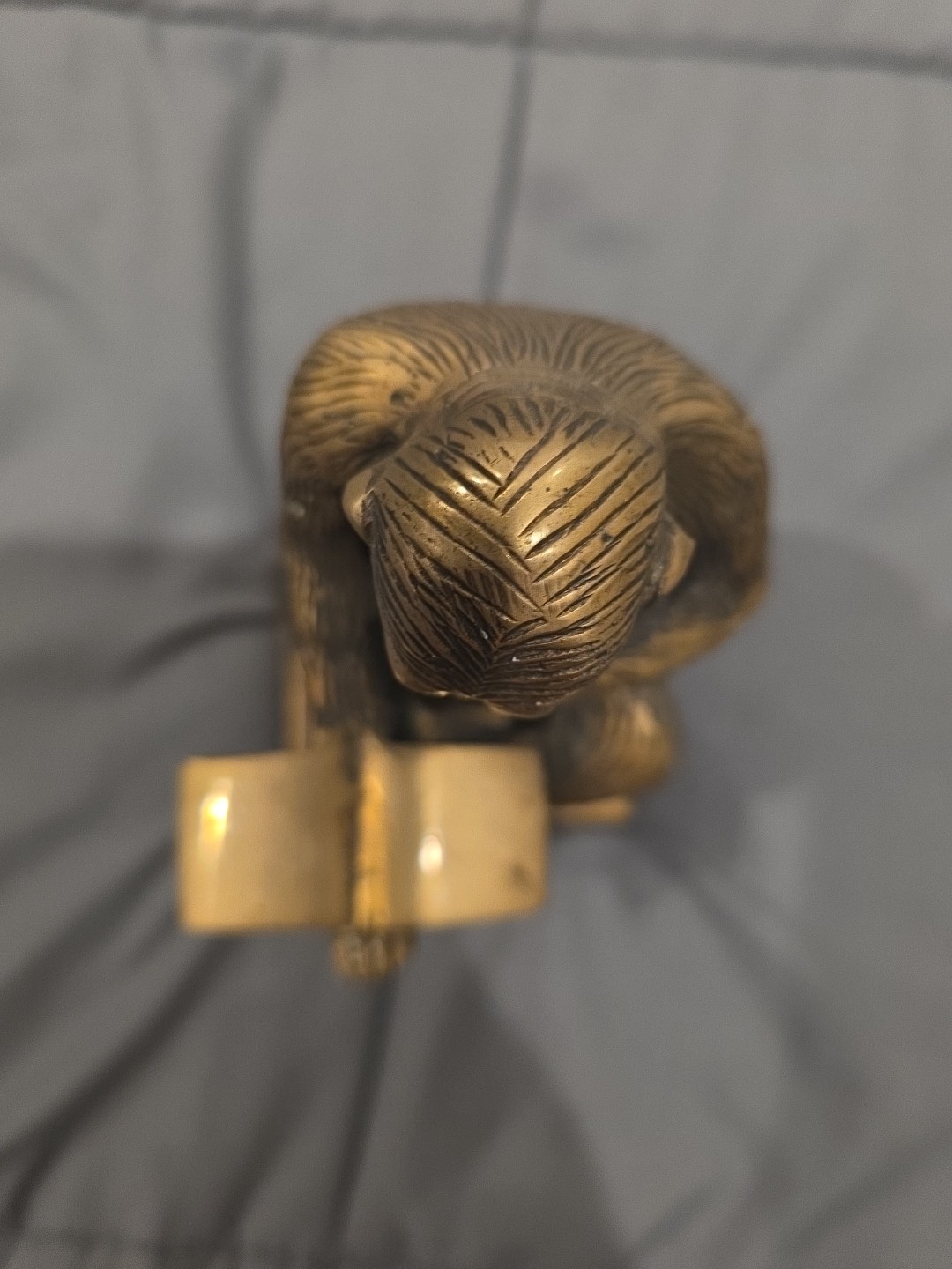 Bronze sculpture. Monkey with a book.