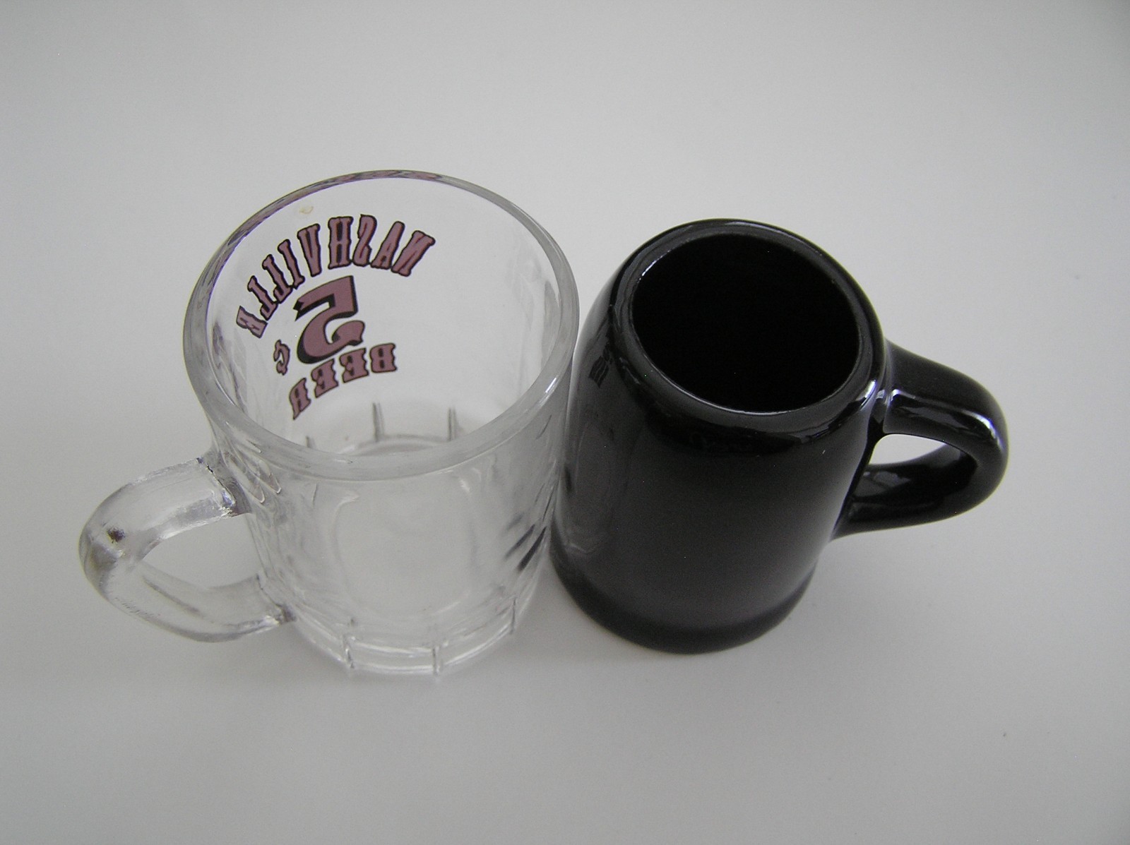 2 Souvenirs Shot Mugs: A Black Rumple Minze and A Clear Nashville 5cents Beer