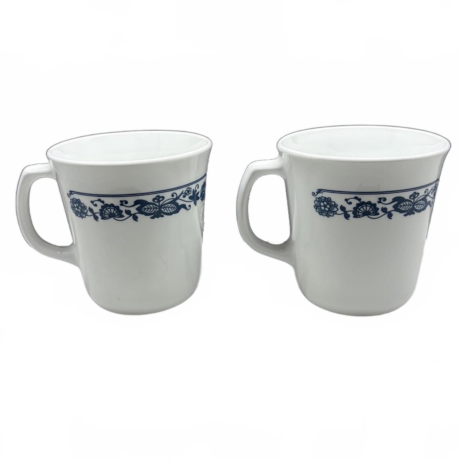 Two white Corning Ware Old Town Blue ceramic mugs with blue floral border.