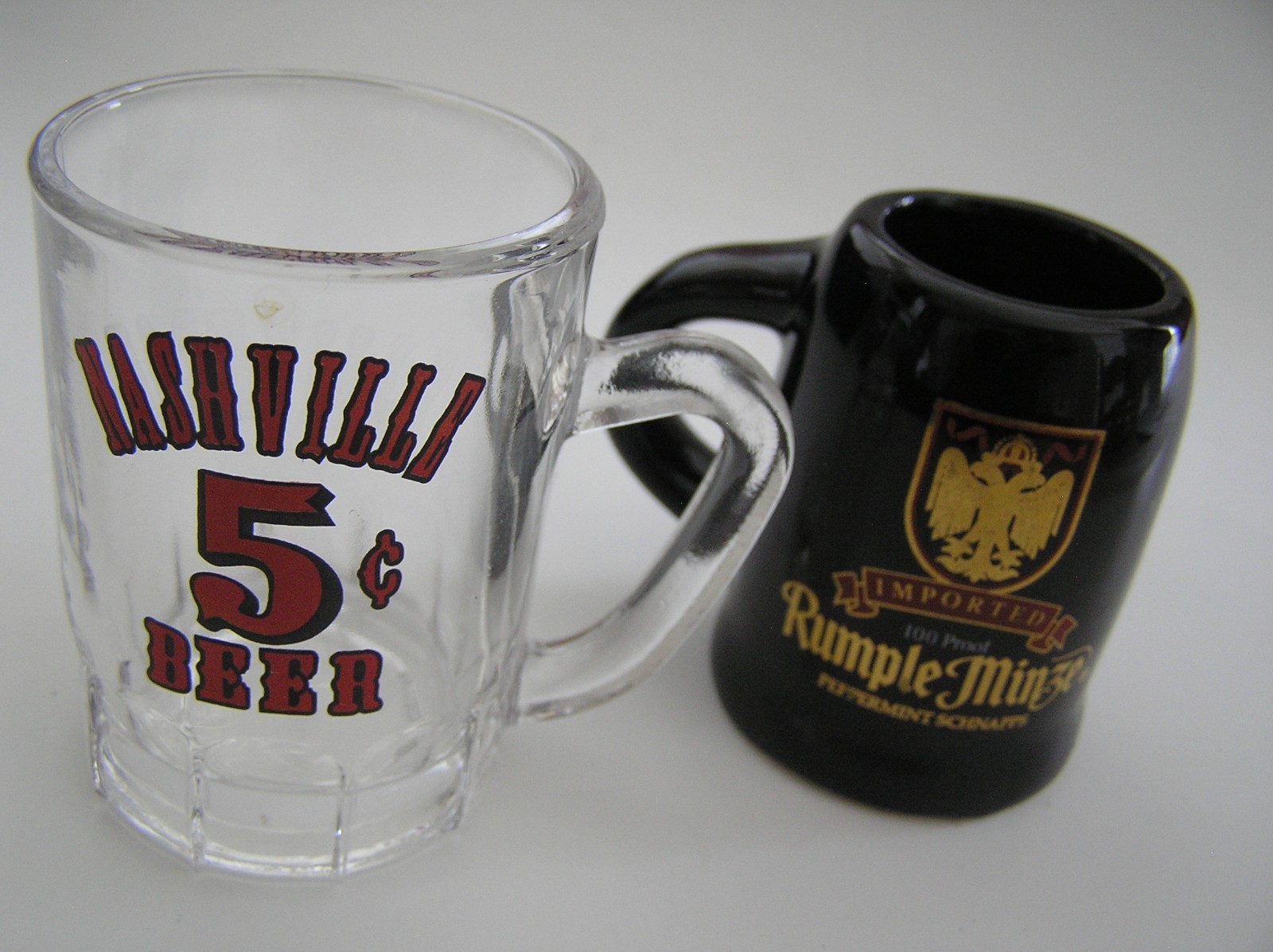 2 Souvenirs Shot Mugs: A Black Rumple Minze and A Clear Nashville 5cents Beer