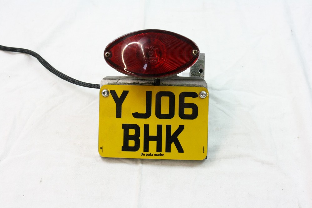 License plate holder side including lighting for Harley