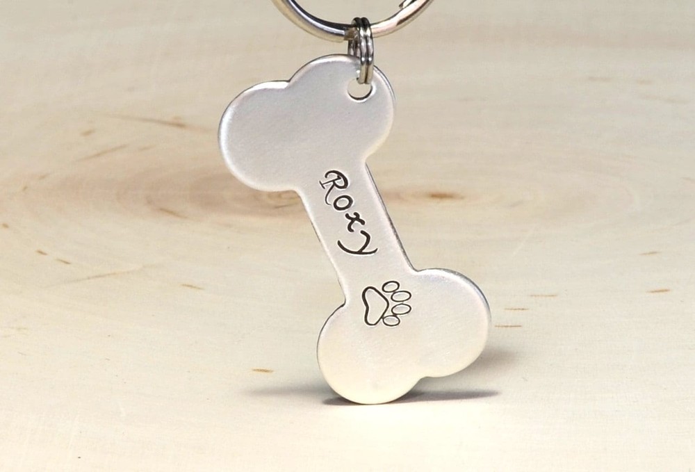 Silver bone shaped dog tag with name and phone number made from solid sterling