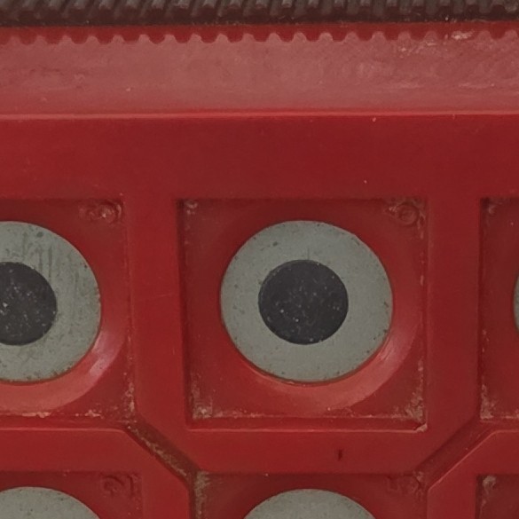 Red Handheld Electronic Game with Circular Buttons and Battery Compartment