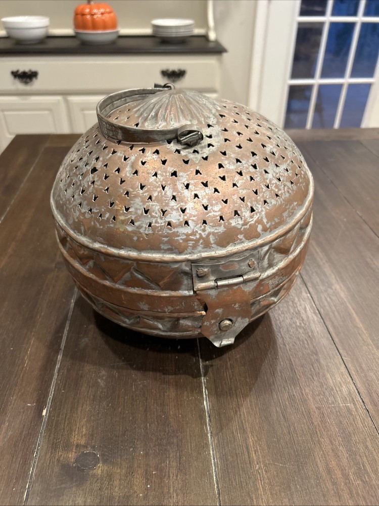 Antique Middle Eastern copper lidded storage container with geometric patterns.