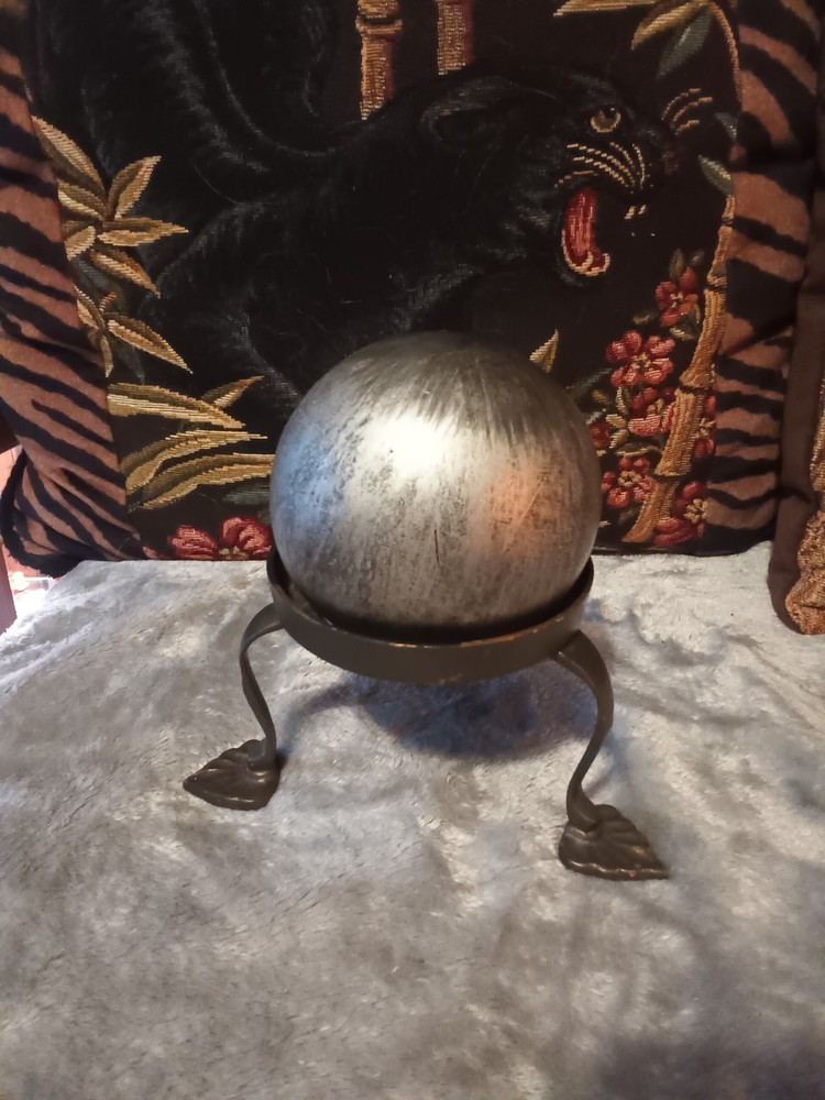 Brushed silver ball,or orb on painted brass base.