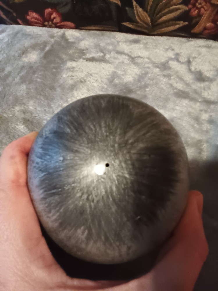 Brushed silver ball,or orb on painted brass base.