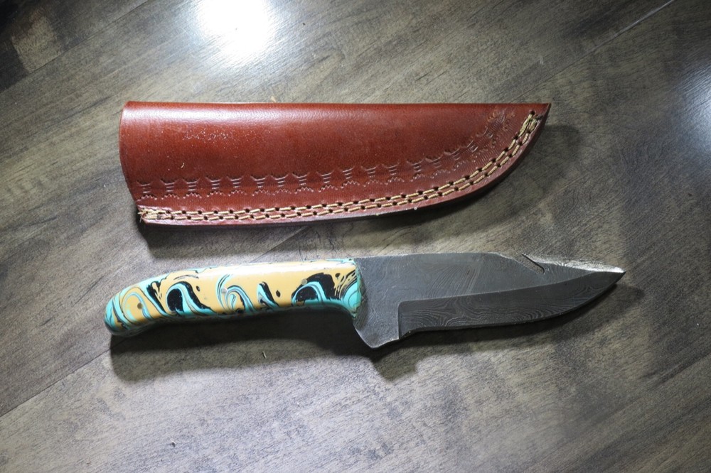 Sleek Damascus knife with multi colored ceramic handle & leather sheath