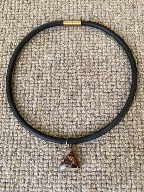jasper triangular pendant set into silver, on a rubber necklace (Germany)