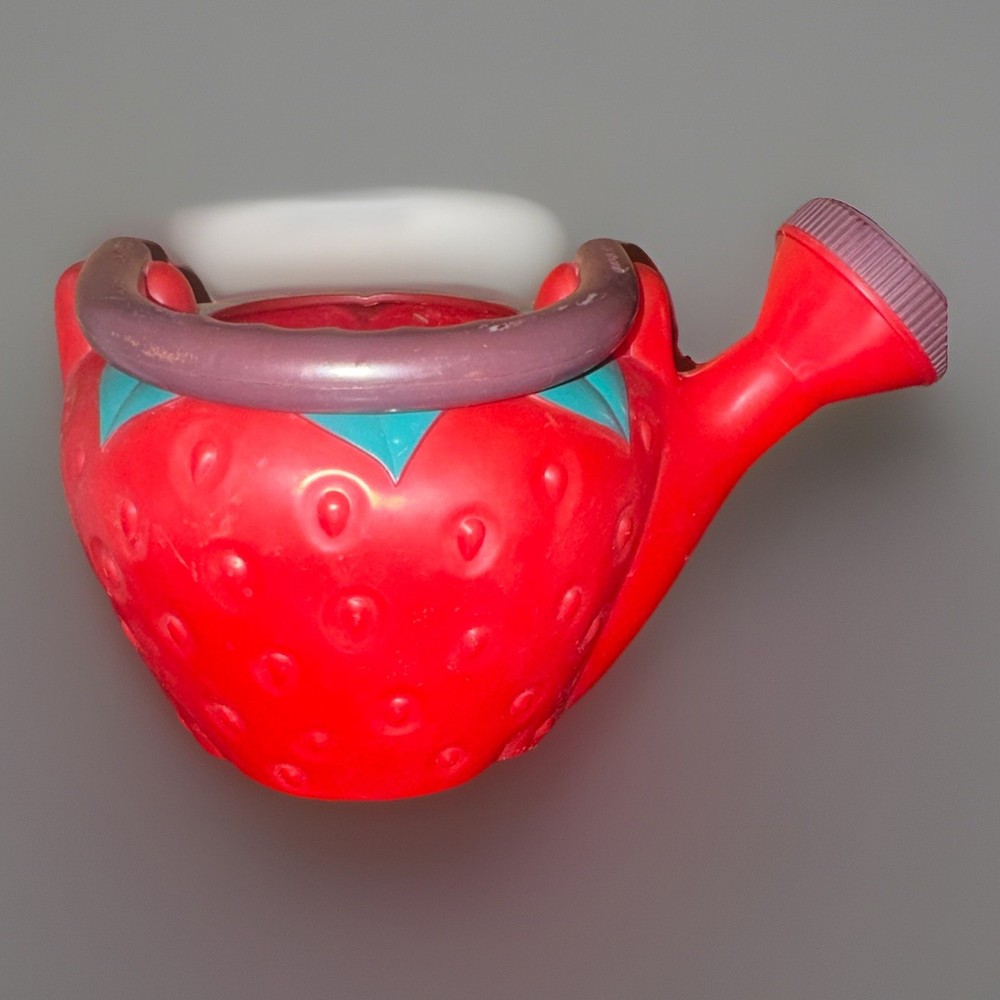 vintage strawberry-shaped plastic watering can