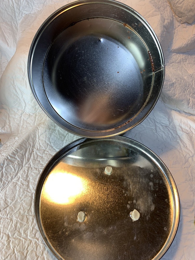 round silver tin with metal golf plaque affixed