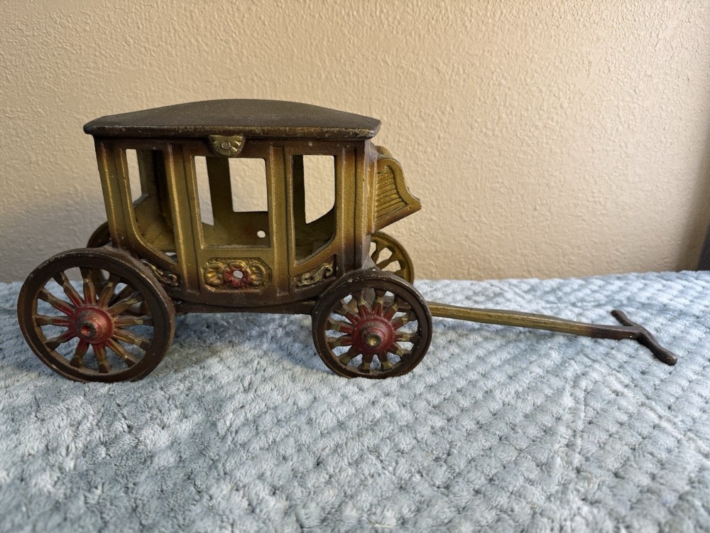 Antique cast iron pull toy carriage with decorative detailing and pull handle