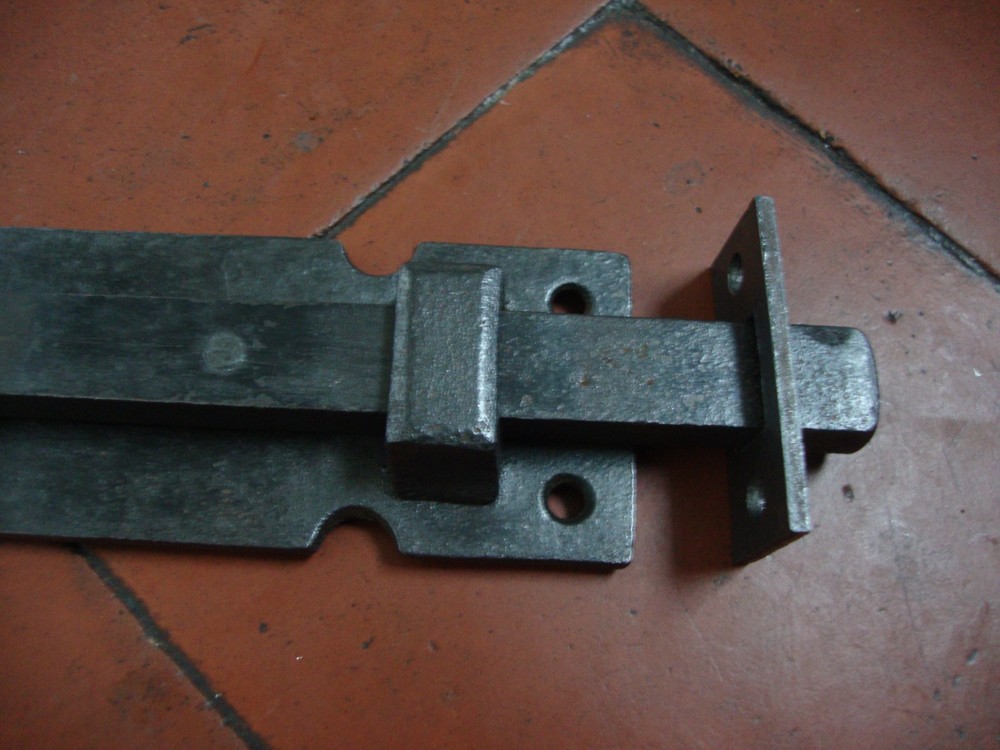 Antique very substantial antique cast iron security door bolt with inset keep