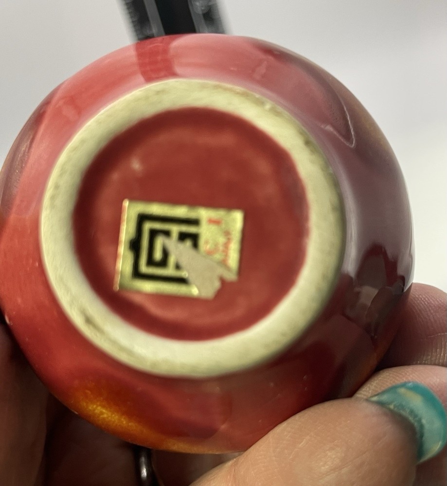 a small, multicolored, drip-glazed ceramic vase.