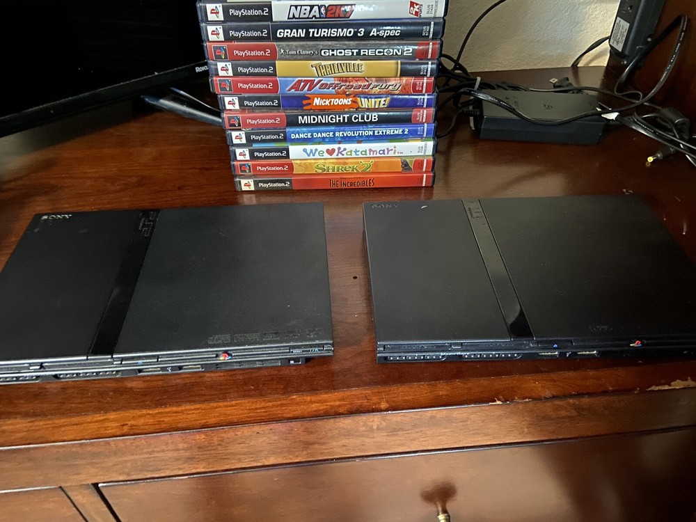 2 Ps2 Slims  (one does Not Read Disc) + 4 Controllers + Memory Card+ 15 Games