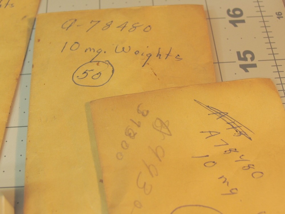 Collection of tiny marked weights 5mg-500mg.