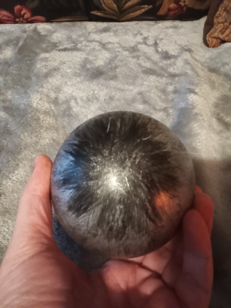 Brushed silver ball,or orb on painted brass base.