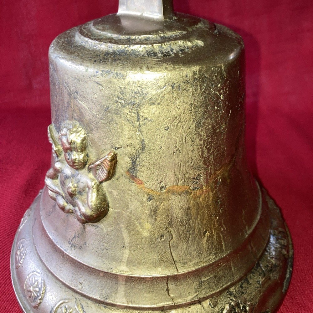 Heavy brass bell with Cupid on each side.