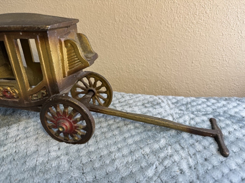 Antique cast iron pull toy carriage with decorative detailing and pull handle