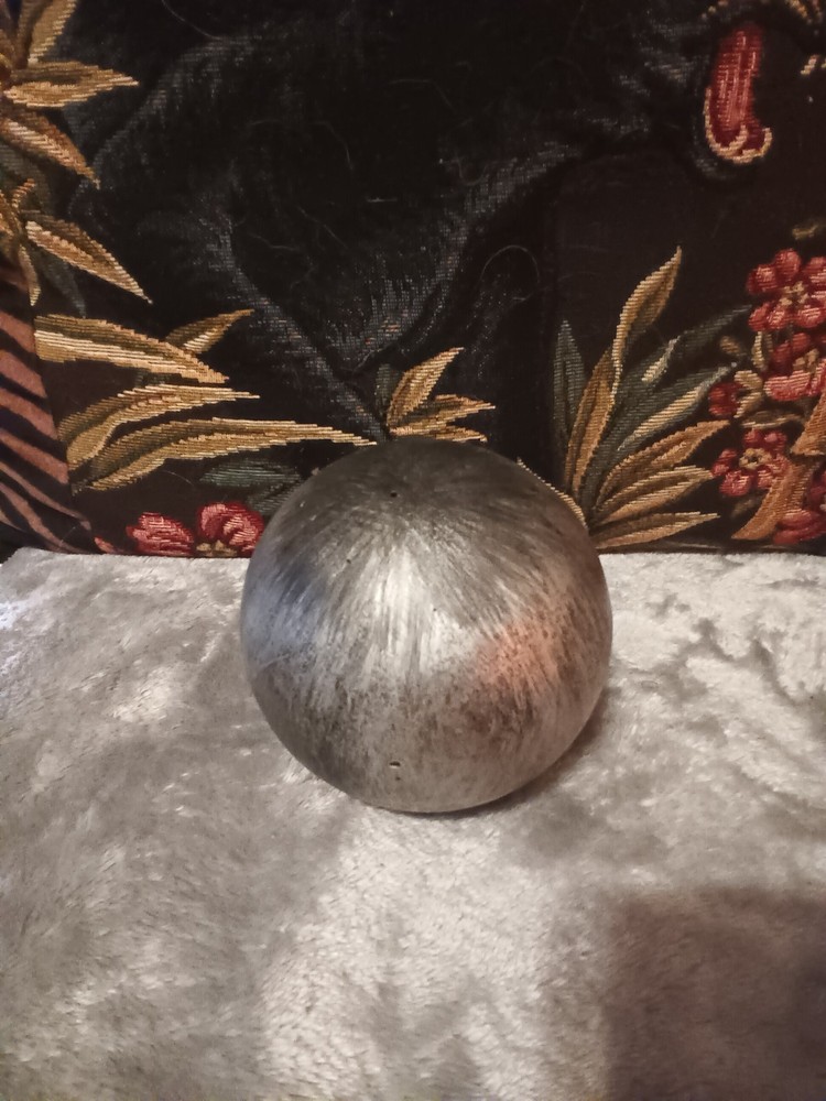Brushed silver ball,or orb on painted brass base.