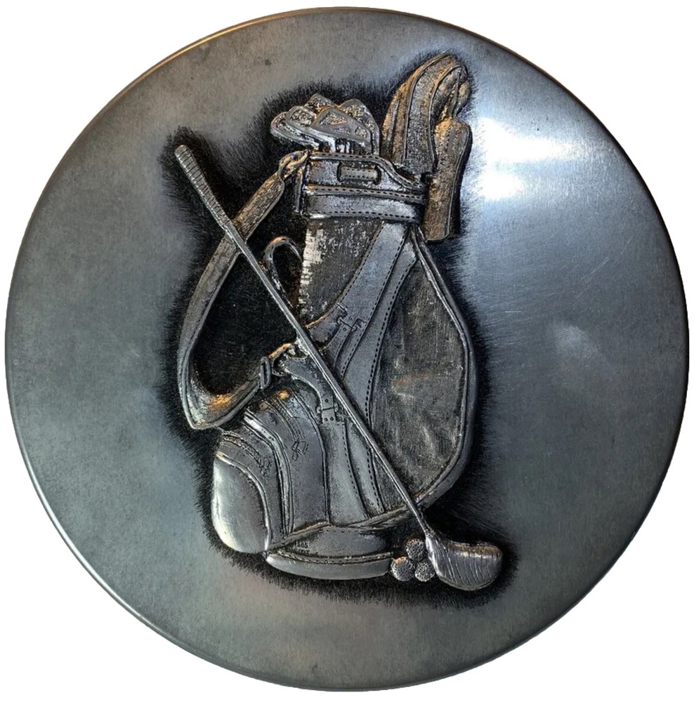 round silver tin with metal golf plaque affixed
