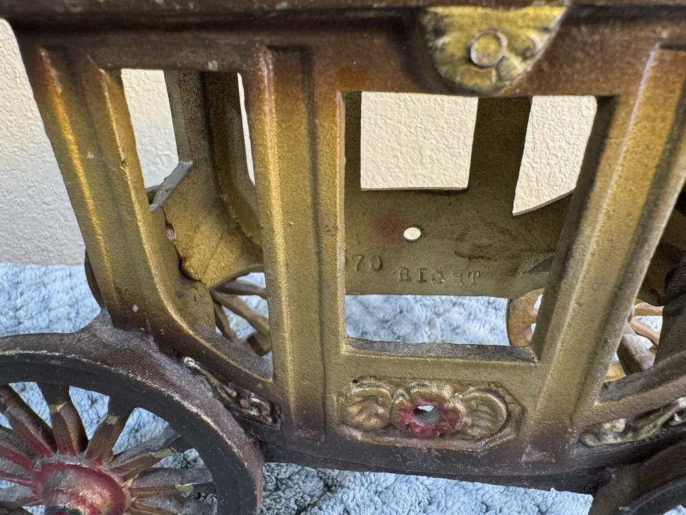Antique cast iron pull toy carriage with decorative detailing and pull handle