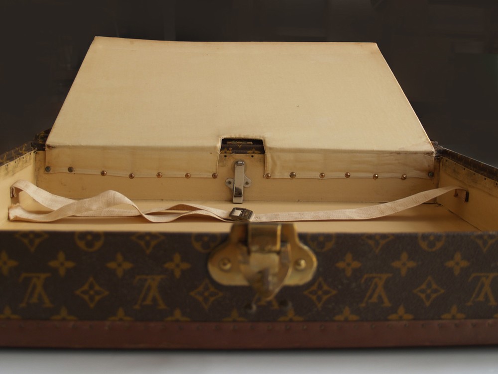 Louis Vuitton monogram suitcase trunk open by center, square handle.