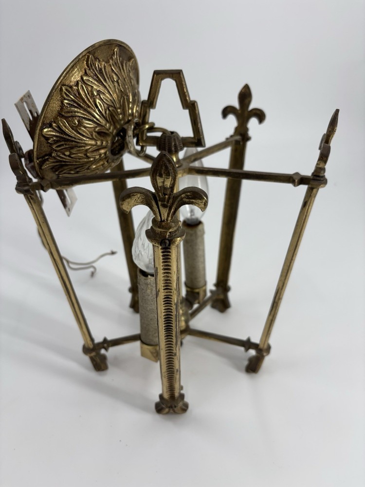 This is an antique lantern chandelier featuring fleur-de-lis finials.