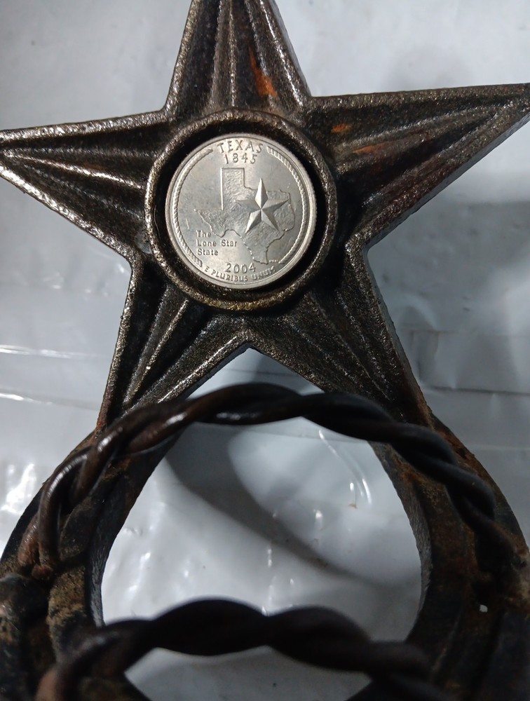 rustic, cast iron desk item featuring a horseshoe base and a large, five-pointed