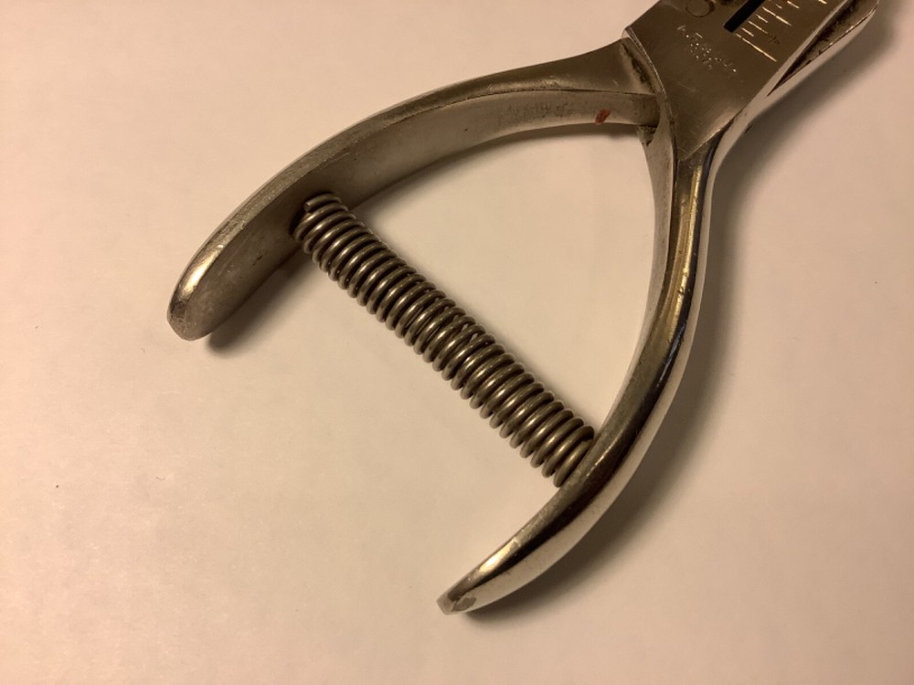 A.F. & Co. hole punch with spring handle action and adjustable punch depth guide