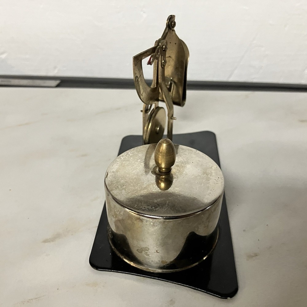 Possibly a brass postage stamp roll holder/dispenser and letter scale