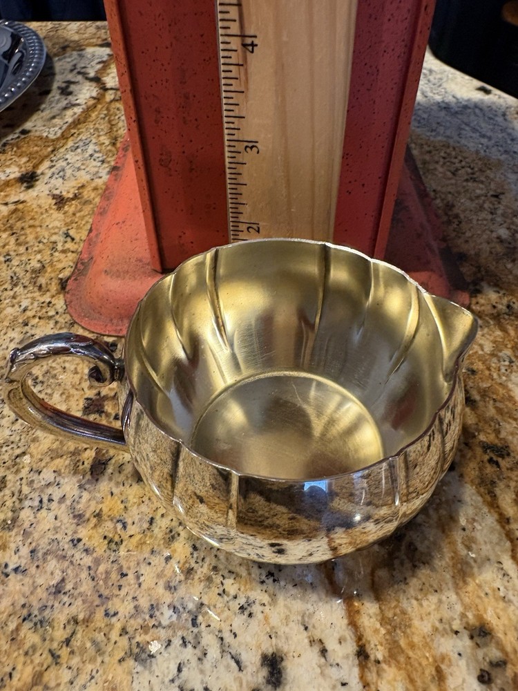 A vintage Oneida silver-plated fluted creamer with a decorative handle.