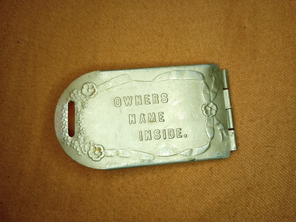 ---Antique hinged aluminum luggage tag “Owners Name Inside”
