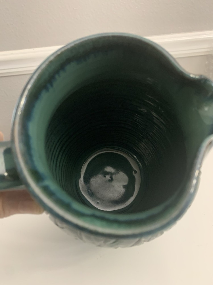 Signed Handcrafted Pottery Pitcher W/ Teal Green Glaze & Raised Leaf Pattern
