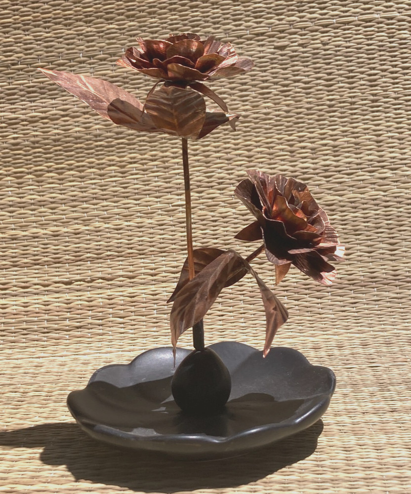 Beautiful copper 'orange' roses with leaf on ceramic base
