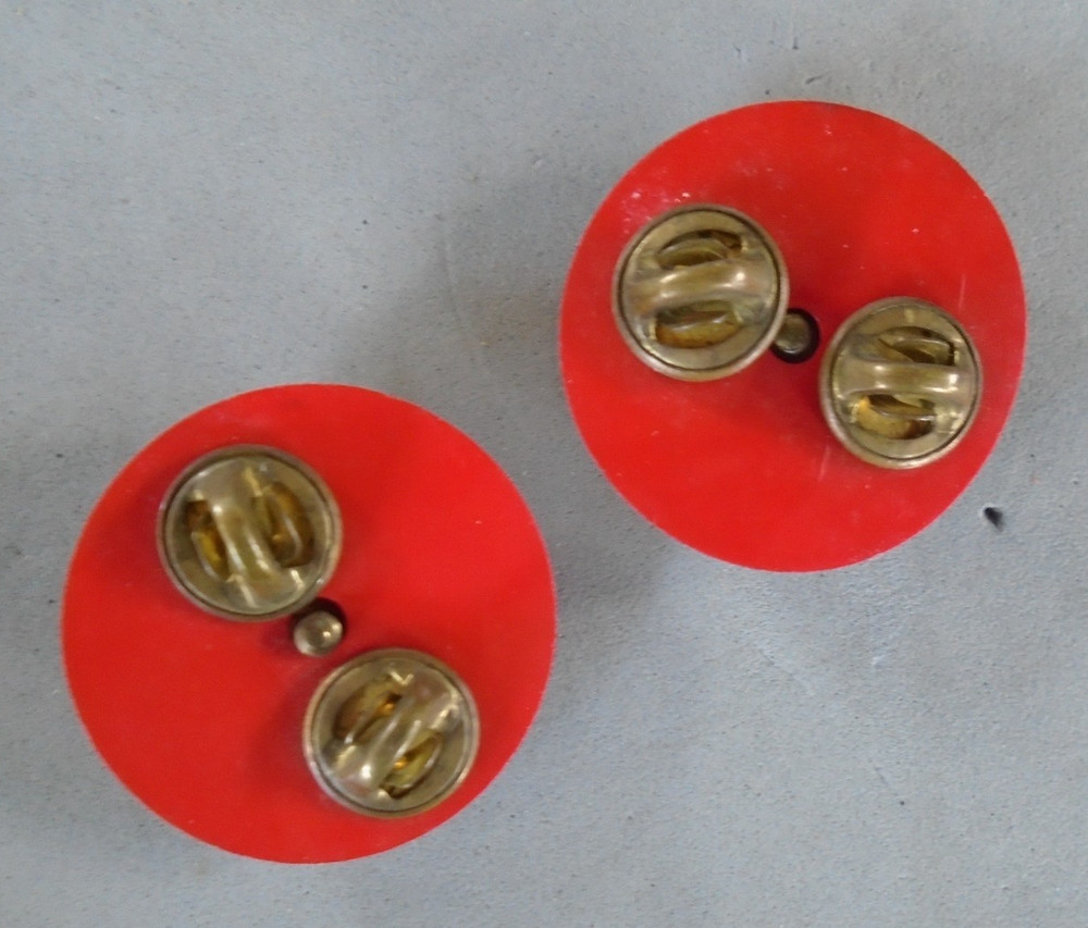 MP and US collar discs on red plastic