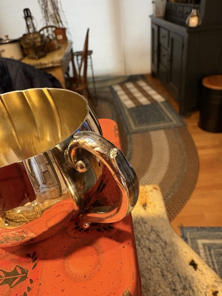 A vintage Oneida silver-plated fluted creamer with a decorative handle.