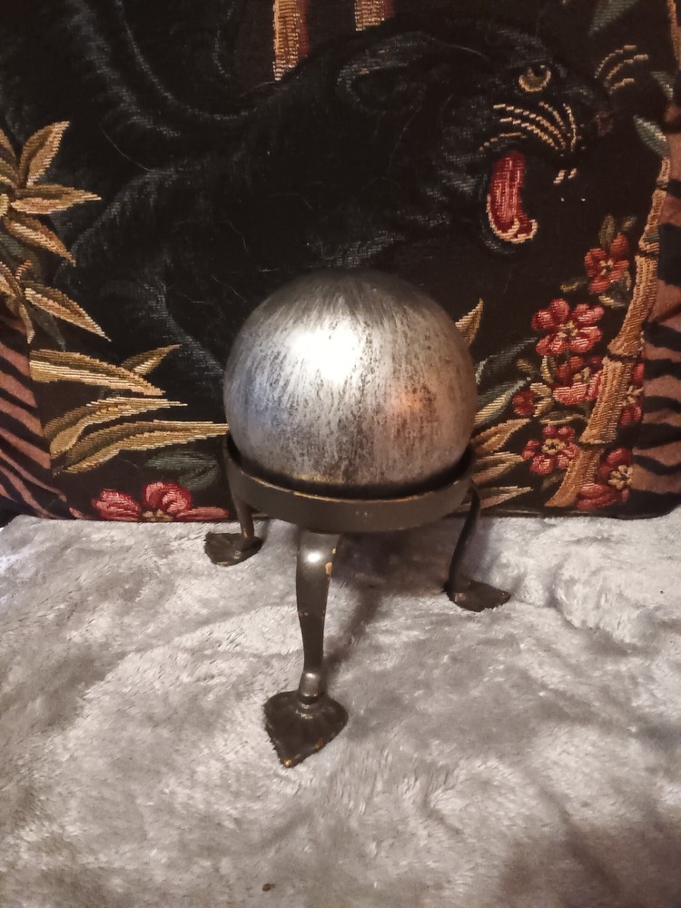 Brushed silver ball,or orb on painted brass base.