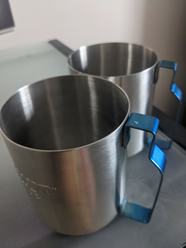 Two stainless absolute mule vodka glasses with blue metal handle