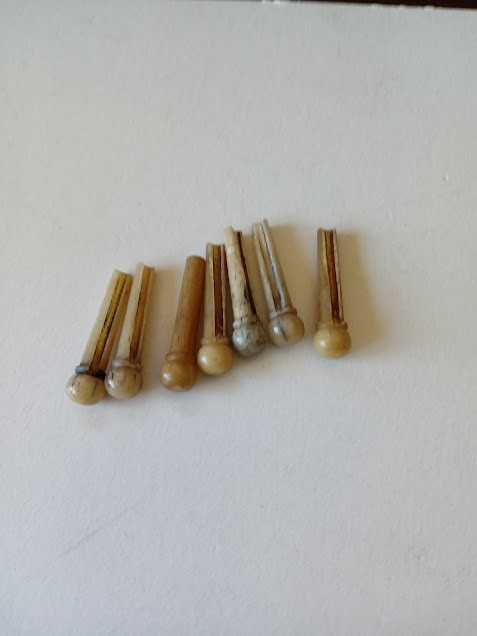 7 Very cool, old bone slotted bridge pins