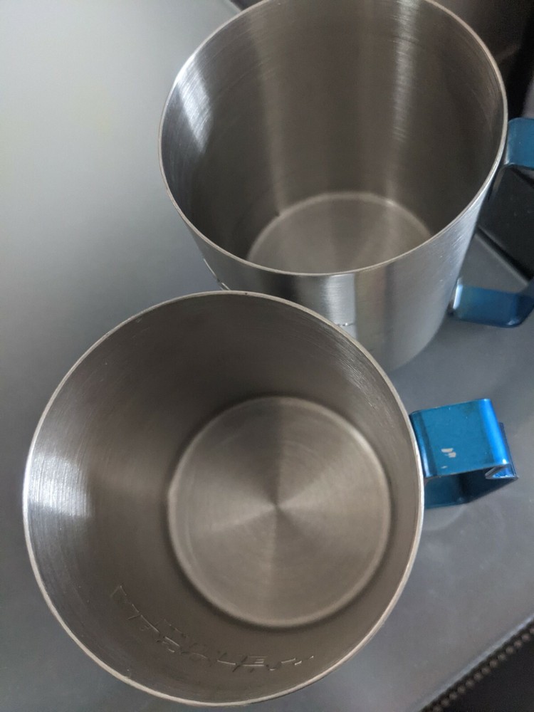 Two stainless absolute mule vodka glasses with blue metal handle