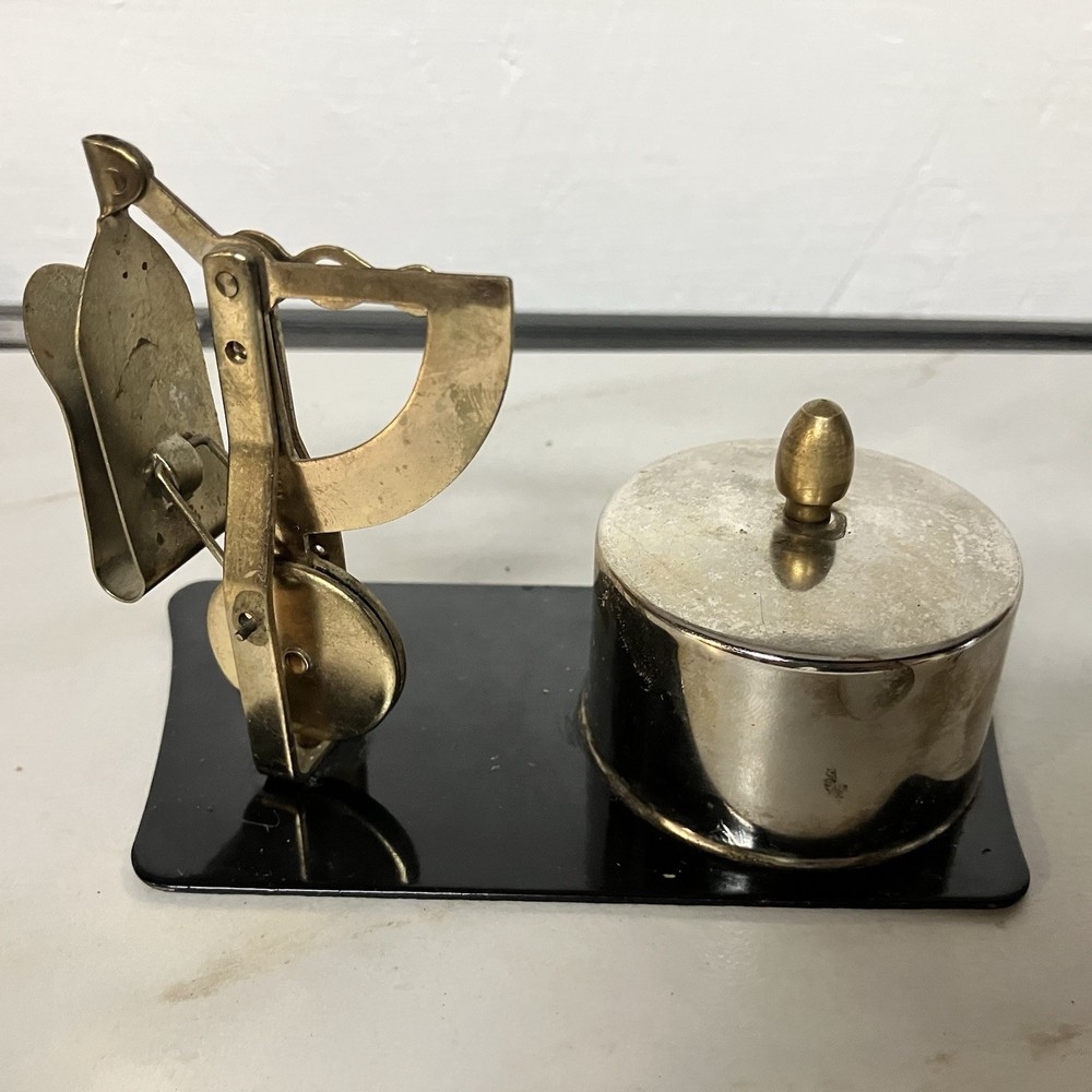 Possibly a brass postage stamp roll holder/dispenser and letter scale