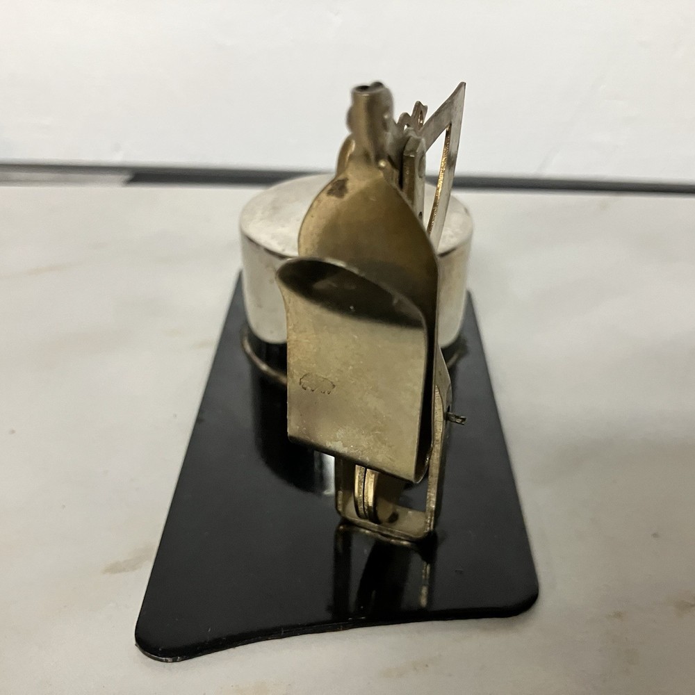 Possibly a brass postage stamp roll holder/dispenser and letter scale